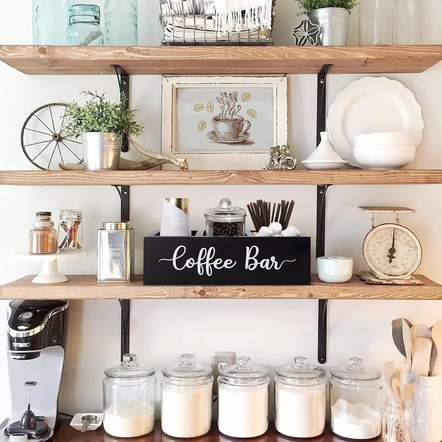 Duvar rafında, kahve makineli bir mutfakta kullanılan, "Coffee Bar" yazılı siyah ahşap düzenleyici kutu.