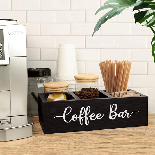 Bir masanın üzerinde, kağıt bardaklar ve kahve çekirdekleri dolu, "Coffee Bar" yazılı ahşap organizer siyah kutu.
